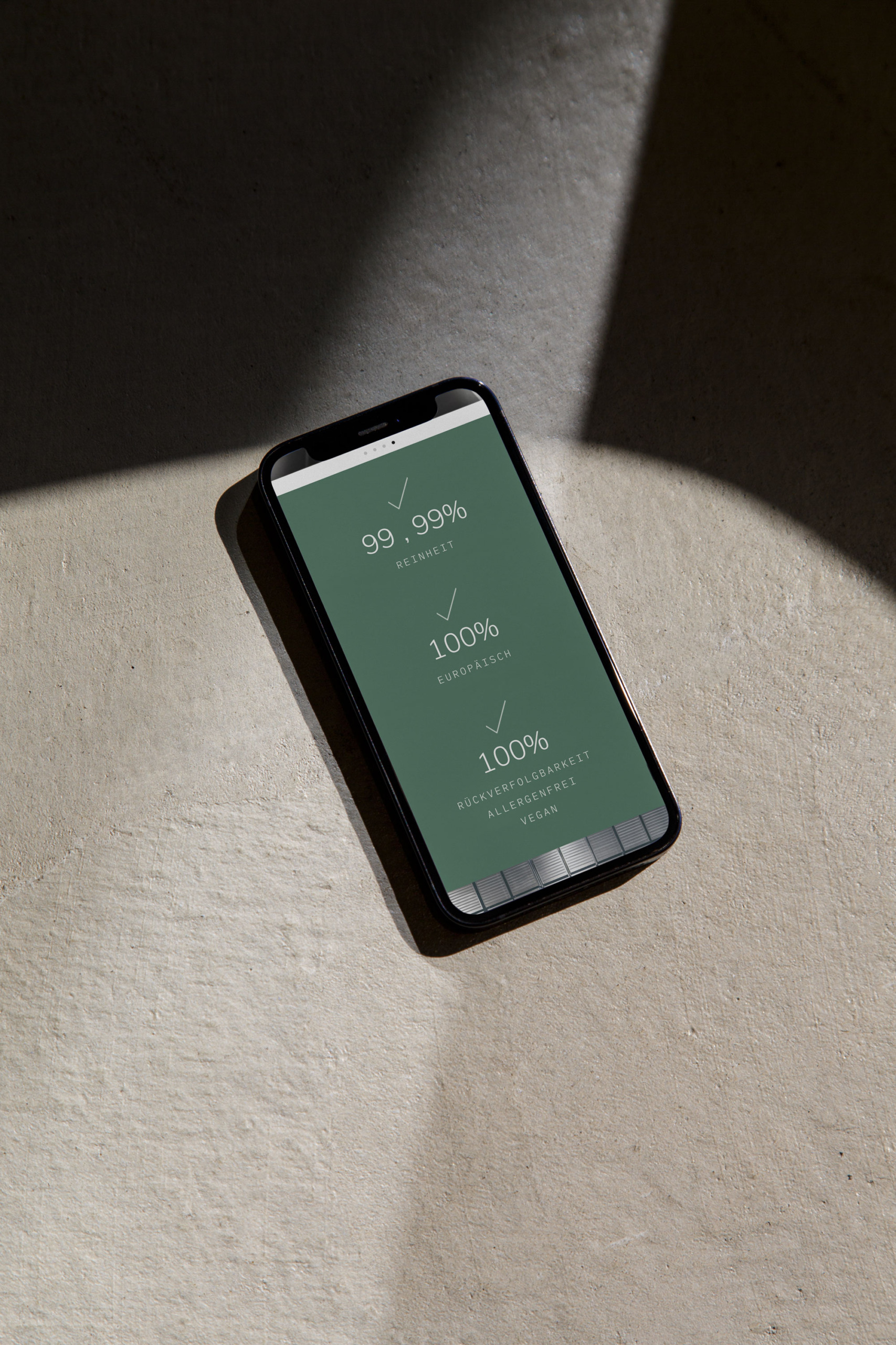 Ein ProKern-Smartphone mit grünem Bildschirm liegt auf einem Betonboden.