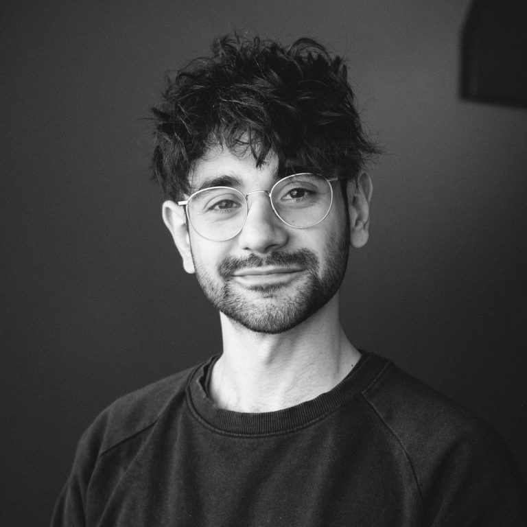 Keywords: photo, black and white

Description: A black and white photo of Nikolaos Goutzeris wearing glasses.