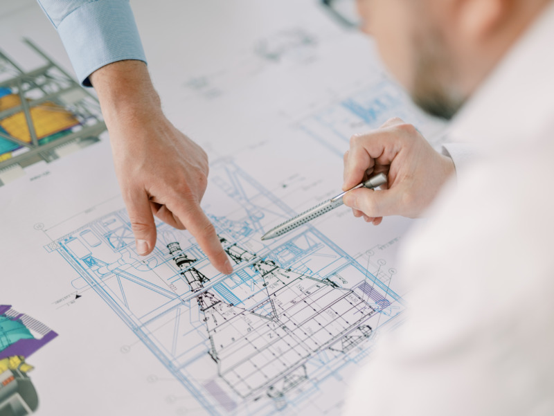 Two people engaged in PMT while looking at blueprints on a table.