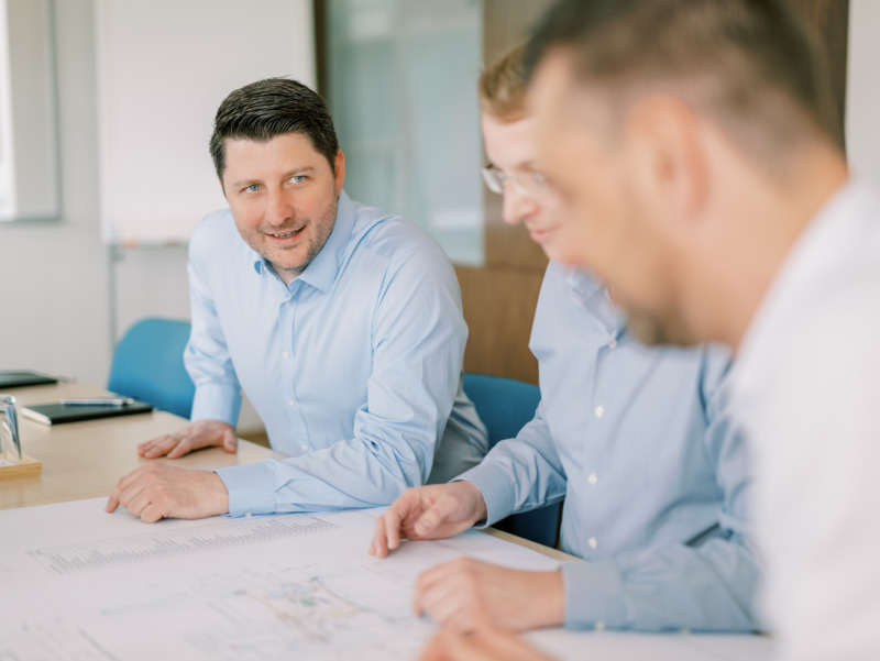 Three PMT members looking at blueprints.