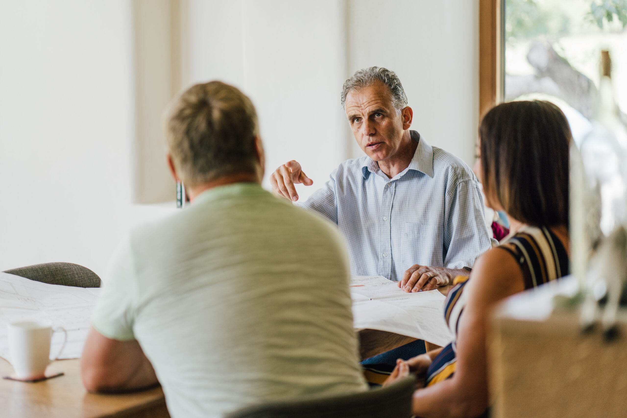 A group of people sitting around a table in a meeting discussing Breitling+Partner.