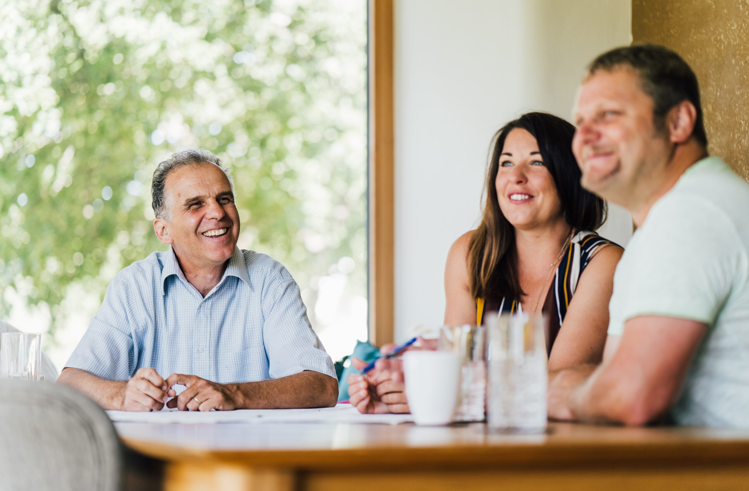 A group of people sitting around a table at a Breitling+Partner event and smiling.