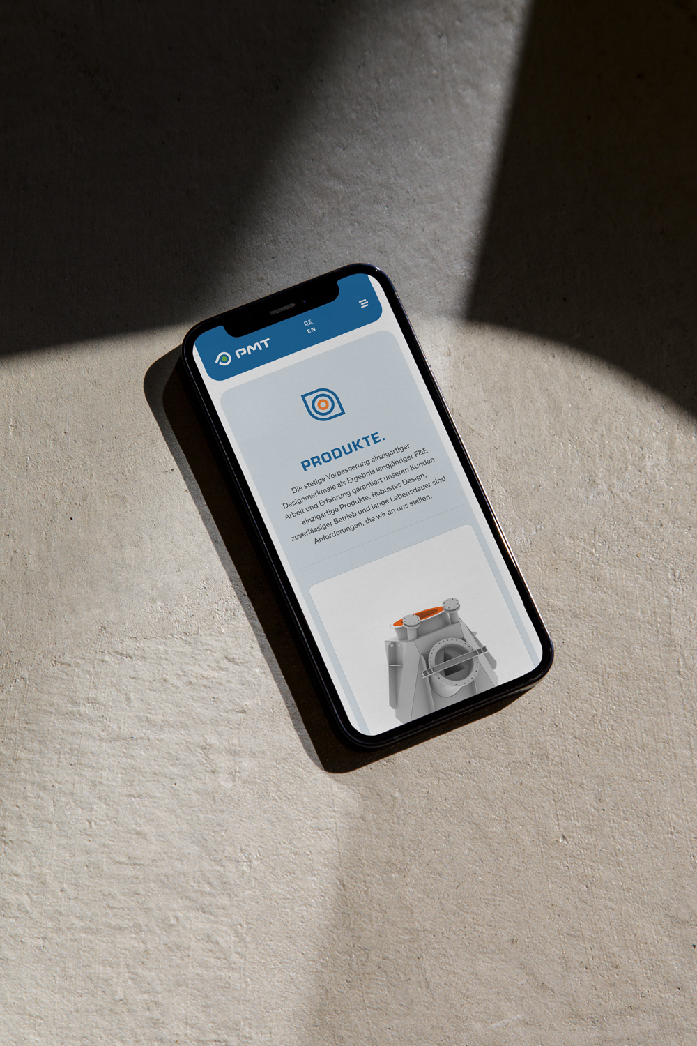 Ein Smartphone, das eine mobile App mit PMT-Funktionalität auf einer Betonoberfläche anzeigt.