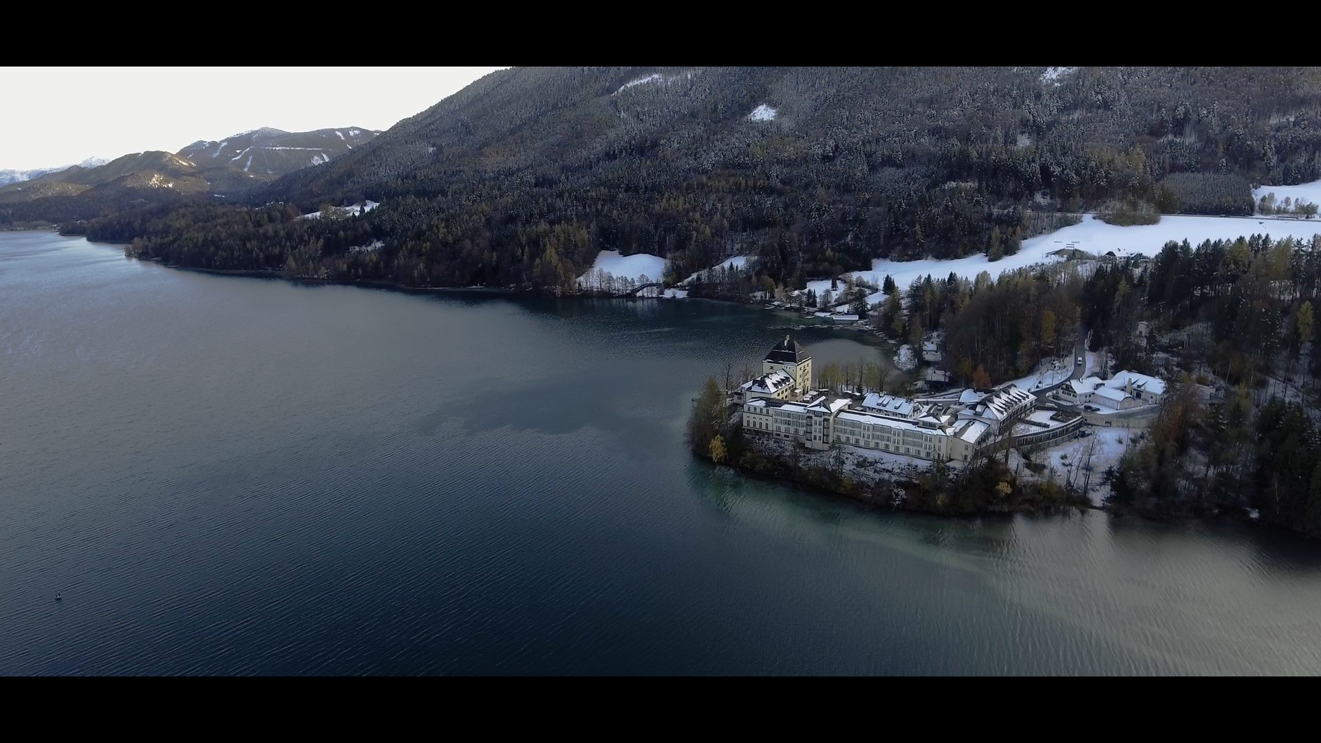 An aerial view of a lake with a castle on it, featuring the Sheraton Hotel.