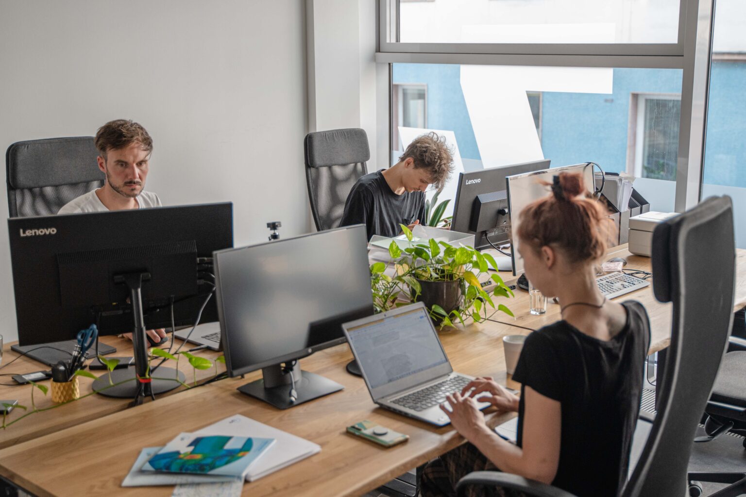 Eine Gruppe von Menschen, die an einem Schreibtisch in einem Büro arbeiten.