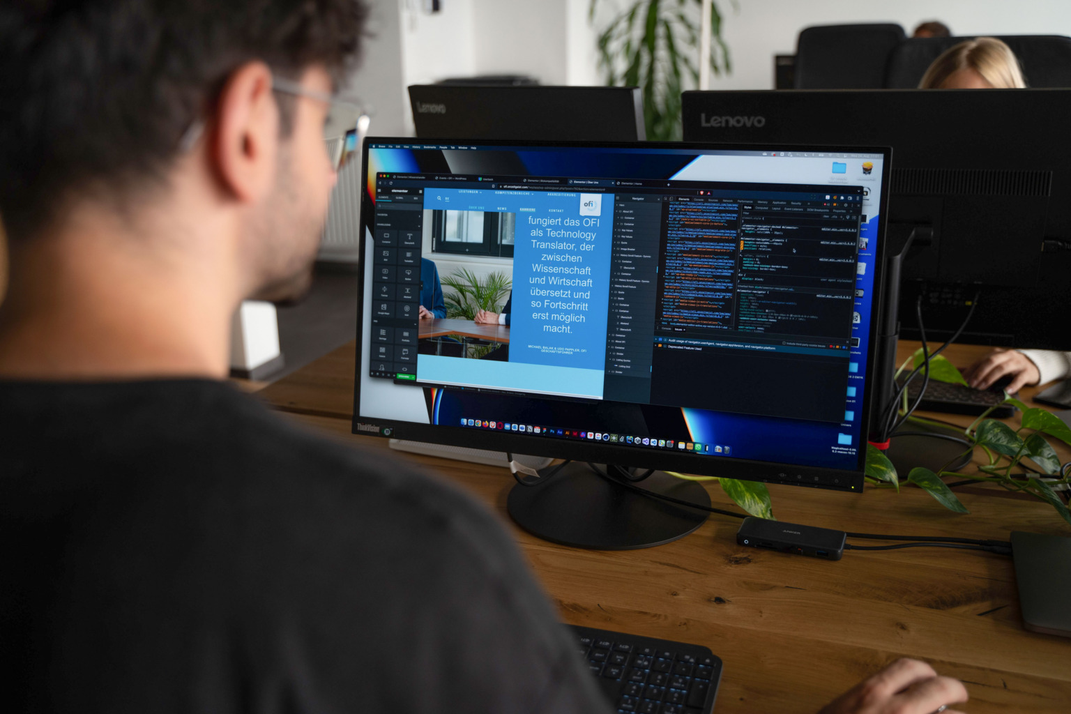 Ein Mann an einem Schreibtisch mit zwei Monitoren, der als Elementor-Agentur arbeitet.