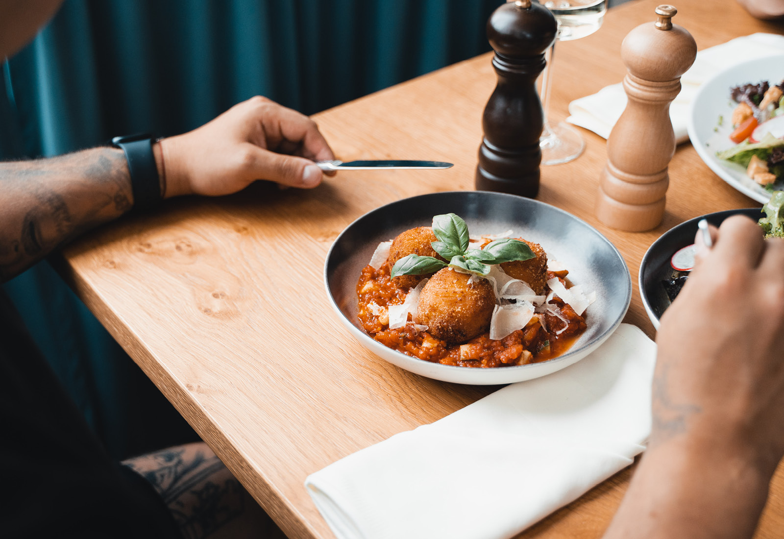 A man and woman eating food at a table.