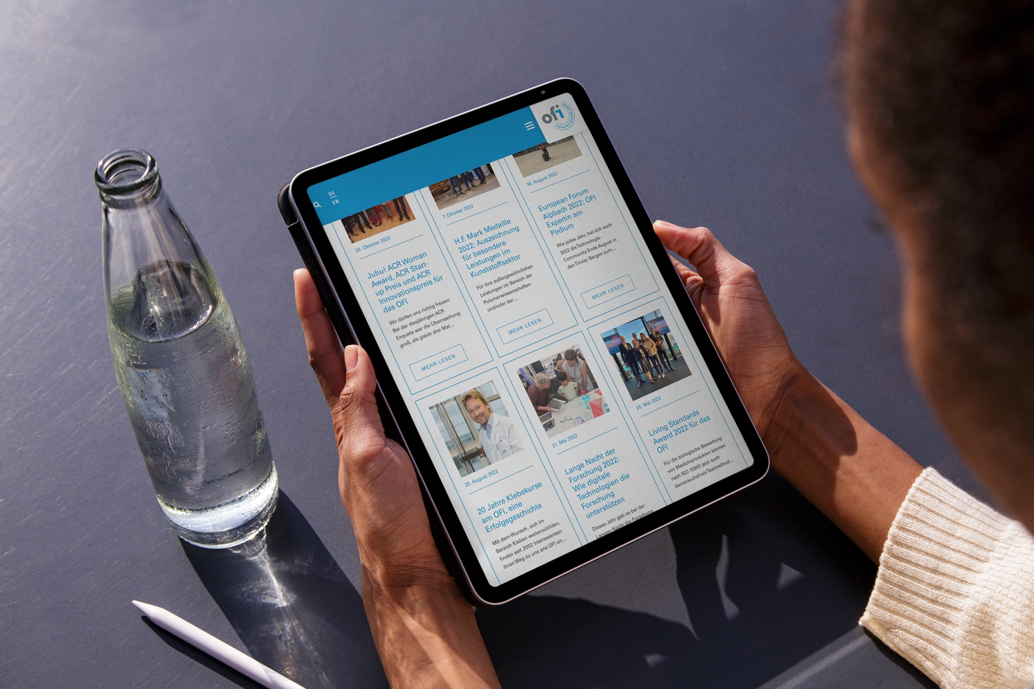 Eine Frau liest in OFI mit einem iPad eine Zeitung.