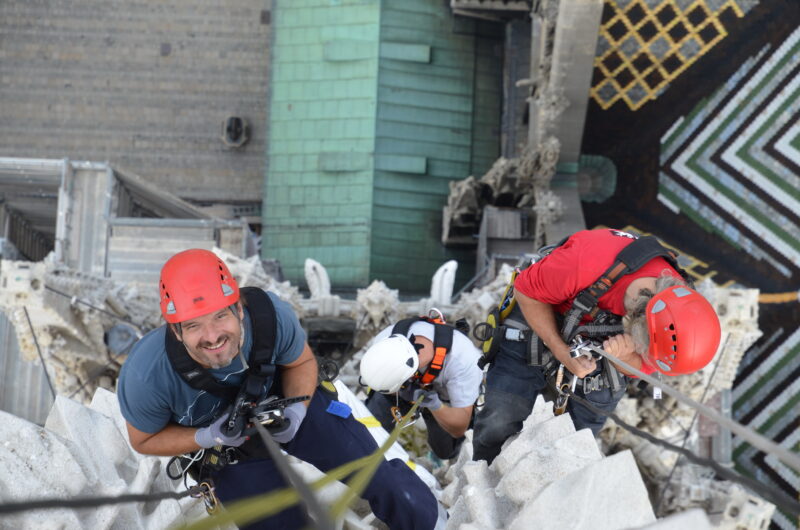 Zwei Männer erklimmen die Seite eines Gebäudes.