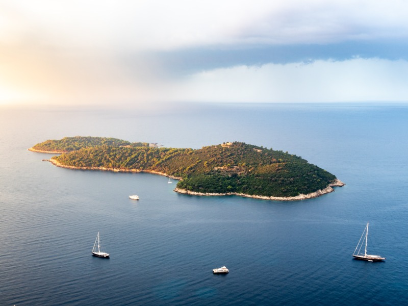 Eine kleine Insel inmitten eines großen Gewässers, perfekt für Yachtcharter.