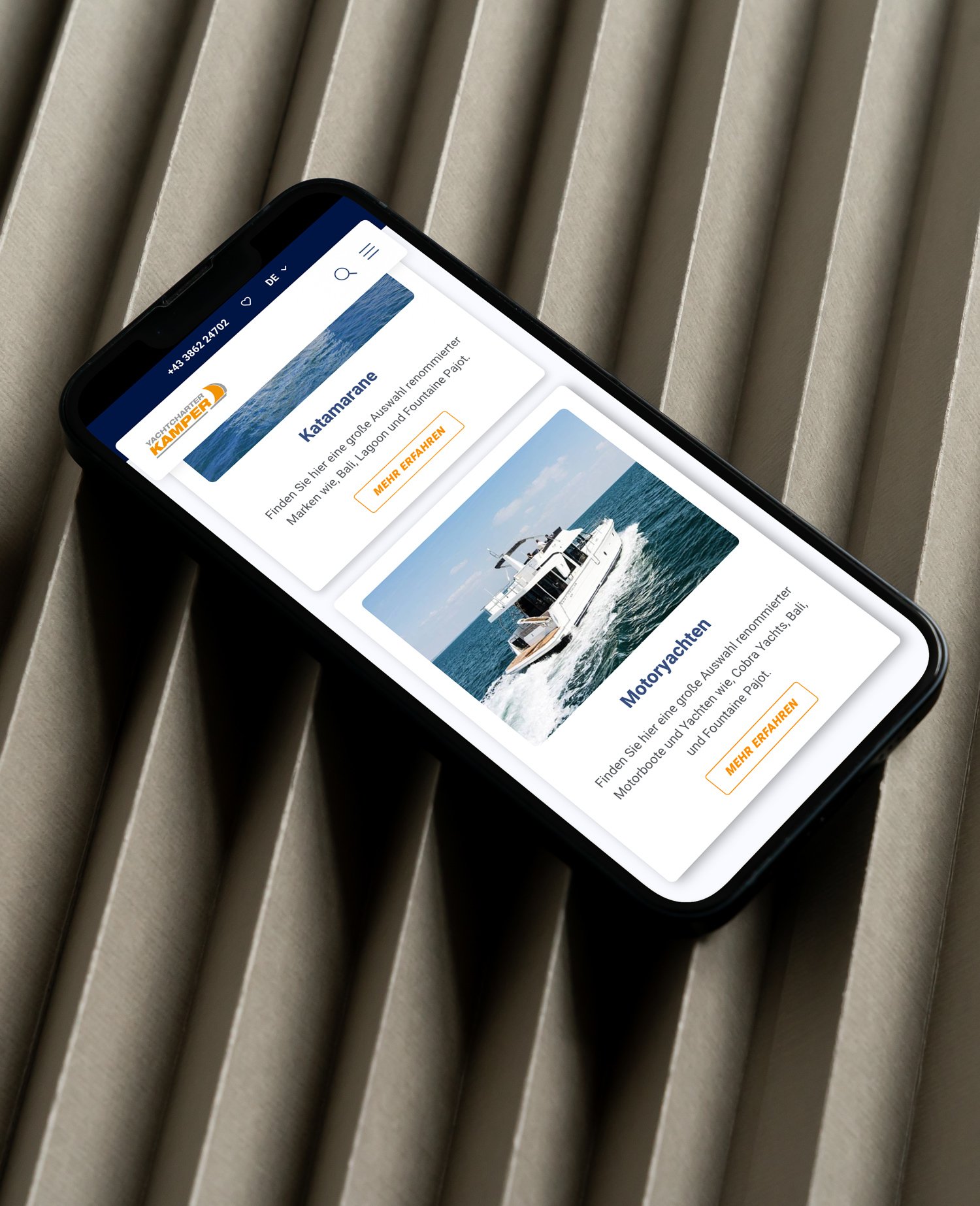 Ein Mobiltelefon, auf dem eine Yacht zu sehen ist.