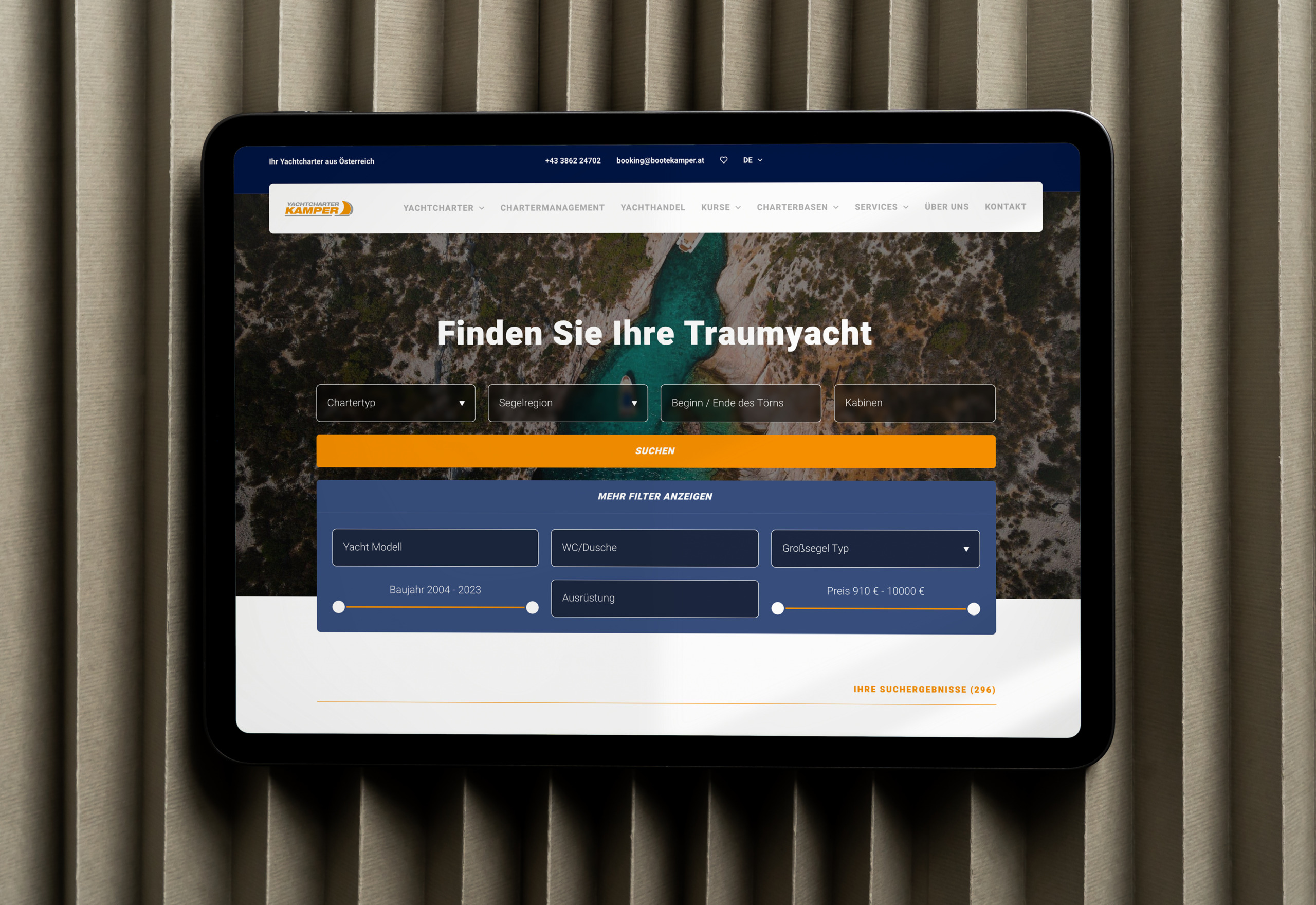 Ein Tablet, auf dem die Startseite der Website von Yachtcharter Kamper angezeigt wird.