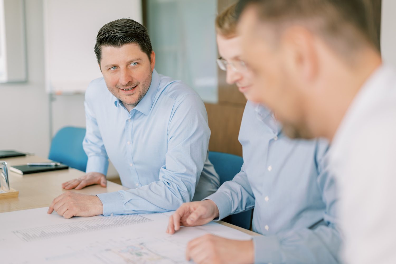 Drei PMTs prüfen Baupläne.