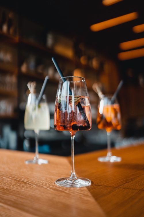 Three glasses of drinks on a wooden table.