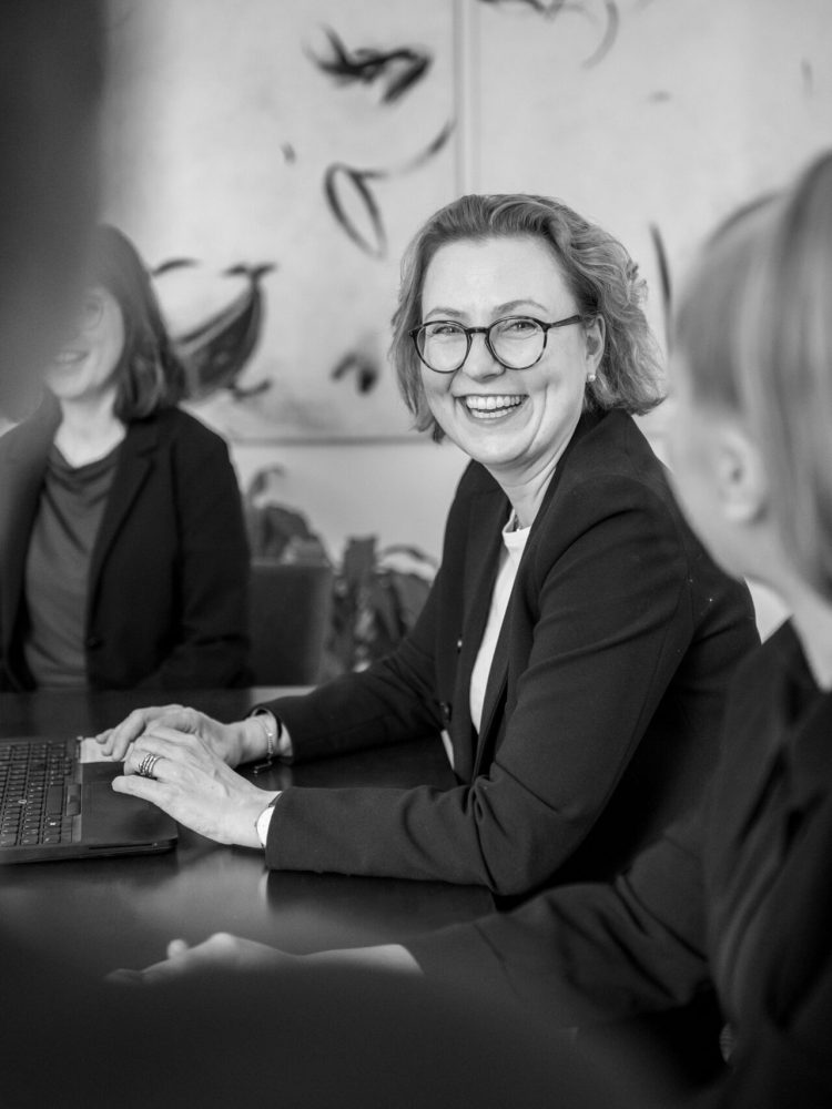 A black and white photo of a group of business people in a meeting, highlighting professionalism.