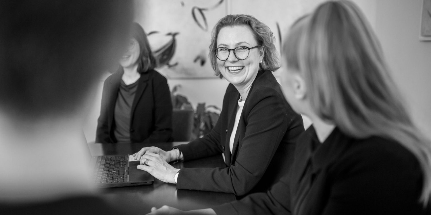 A black and white photo of a group of business people in a meeting, highlighting professionalism.