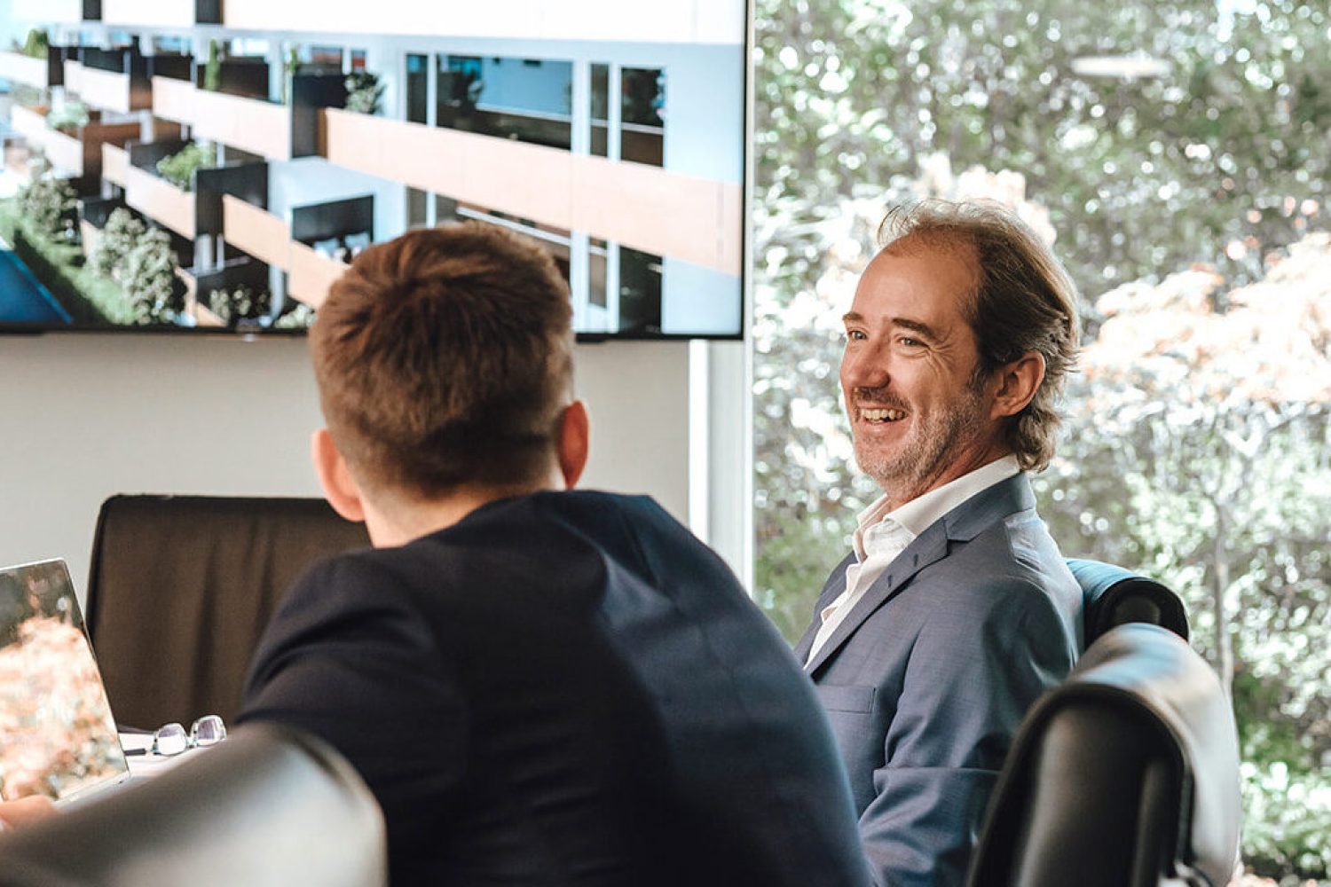 A group of people sitting around a table in a conference room, discussing Valere.