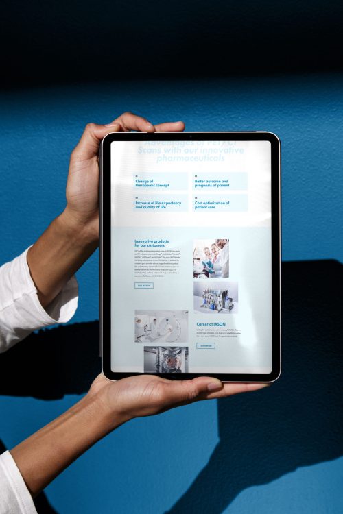 A woman holding an iPad with a blue background. (no keywords added)