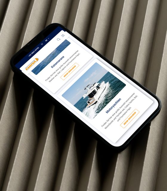 Ein Mobiltelefon, auf dem eine Yacht zu sehen ist. Ein Mobiltelefon, auf dem eine Yacht zu sehen ist.