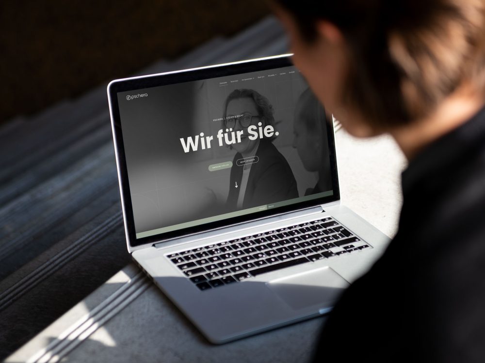 Eine Frau schaut auf einen Laptop mit der PMT-Website darauf.