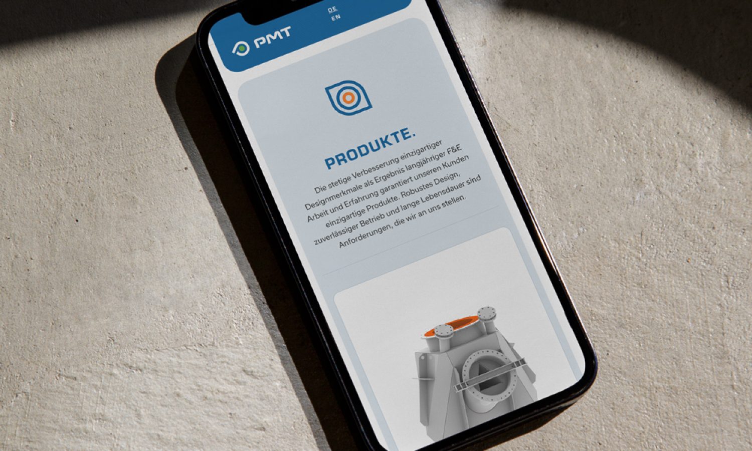 Ein Smartphone, das eine mobile App mit PMT-Funktionalität auf einer Betonoberfläche anzeigt.