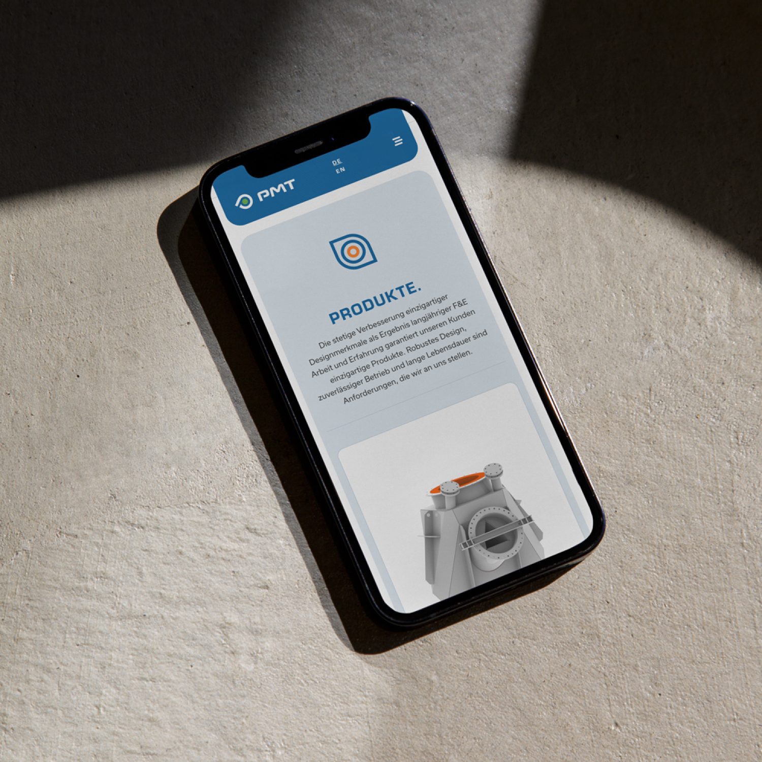 Ein Smartphone, das eine mobile App mit PMT-Funktionalität auf einer Betonoberfläche anzeigt.