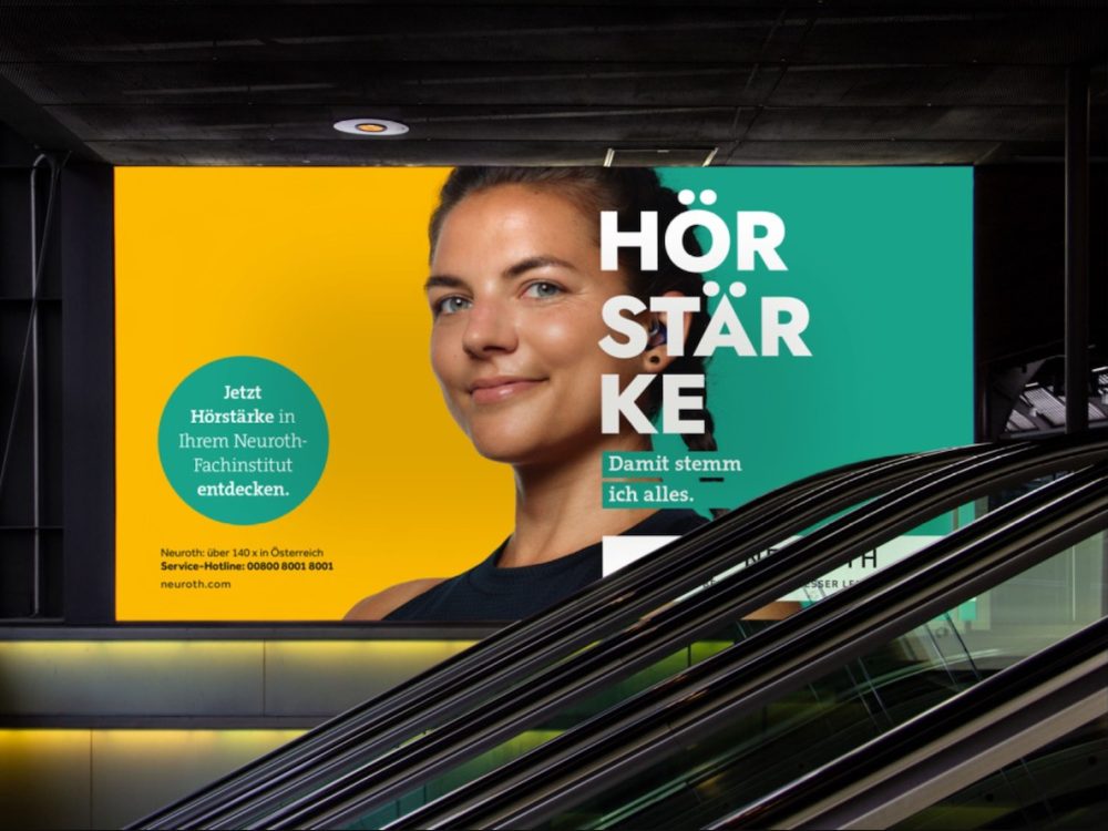 Eine Rolltreppe mit einer Werbung für Neuroth Hörgeräte.