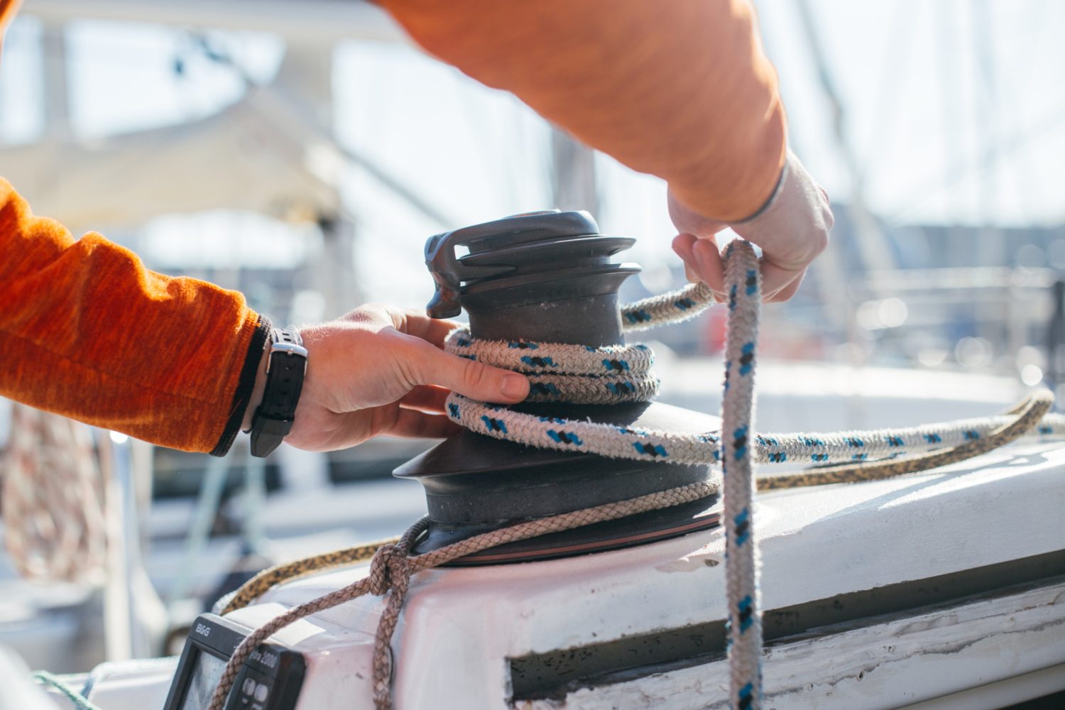 Eine Person bindet ein Seil auf einer Yacht. Eine Person bindet ein Seil auf einer Yacht.
