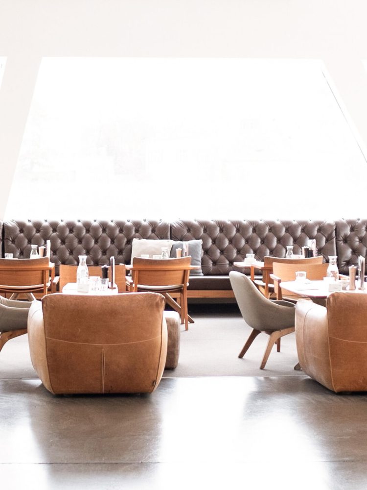 The interior of a Freiblick Tagescafé with wooden tables and chairs.