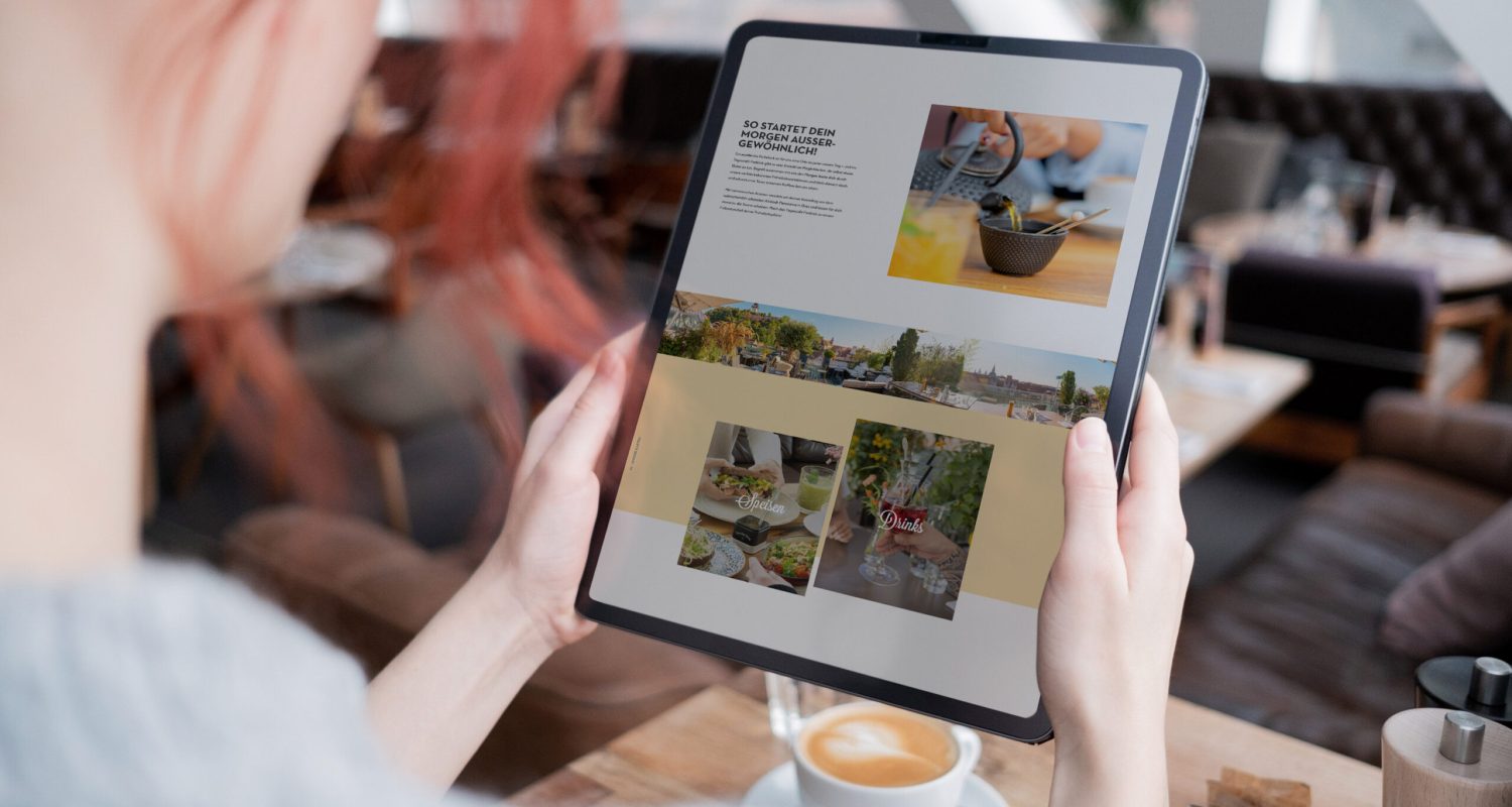 A woman using an iPad to view a website while sitting at Freiblick.