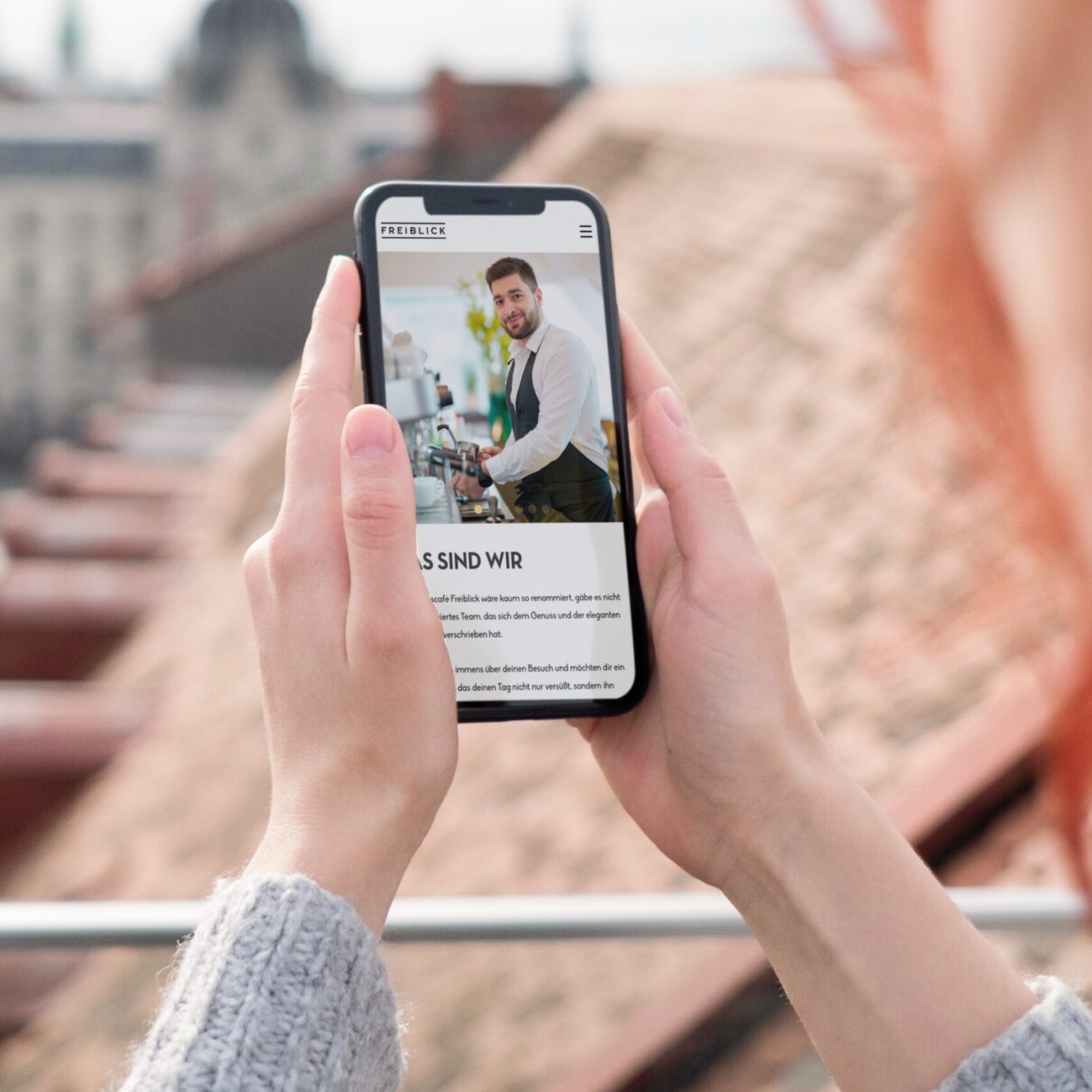 Eine Frau macht mit ihrem Handy ein Foto vom Restaurant Freiblick.