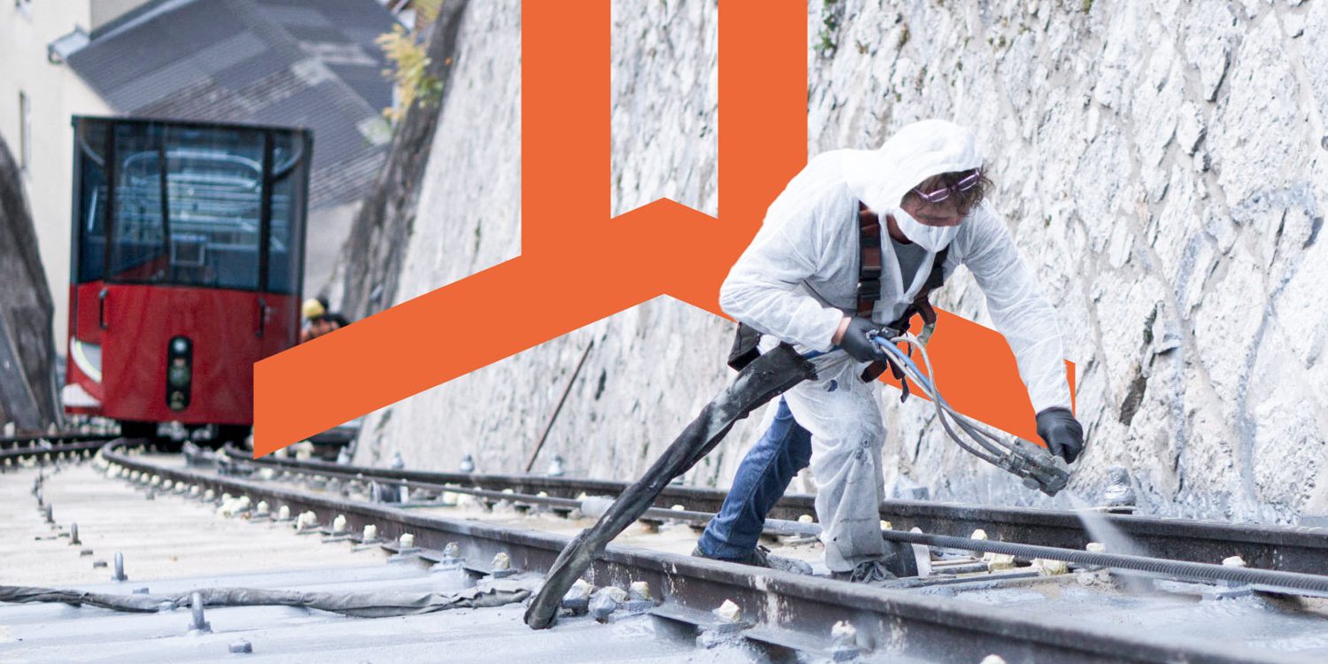 A man in a white jacket is working on a Polyflex train track.