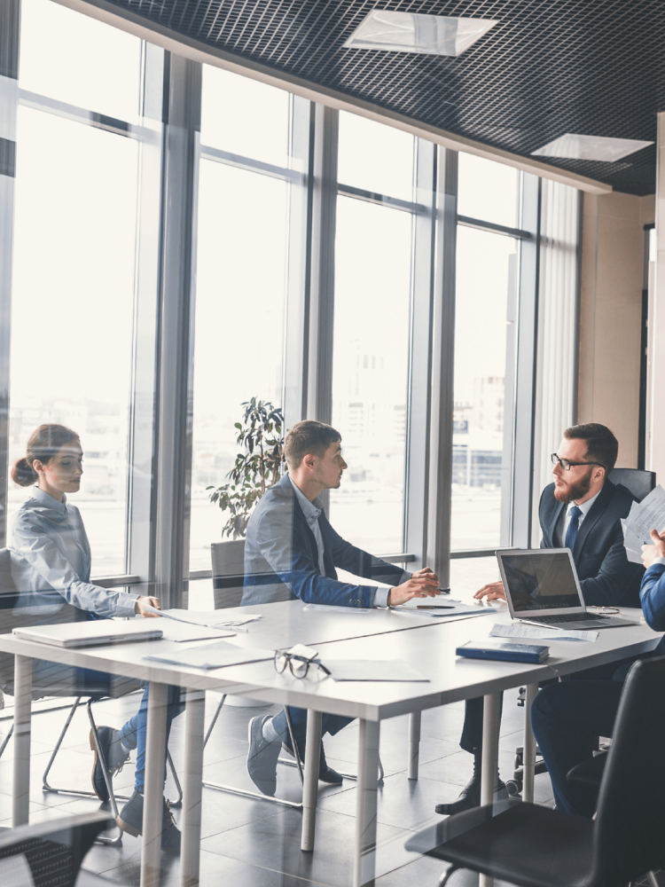 A group of Blechinger sitting around a table in a conference room. A group of Blechinger sitting around a table in a conference room.