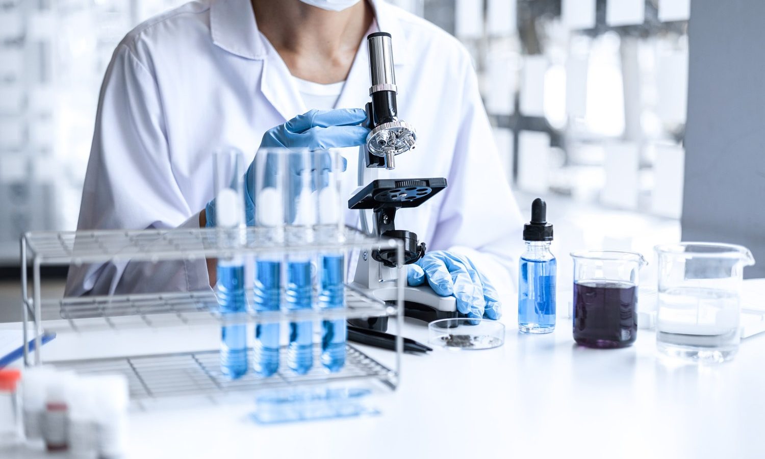 Ein Wissenschaftler benutzt ein Mikroskop in einem Labor. Ein Wissenschaftler benutzt ein Mikroskop in einem Labor.