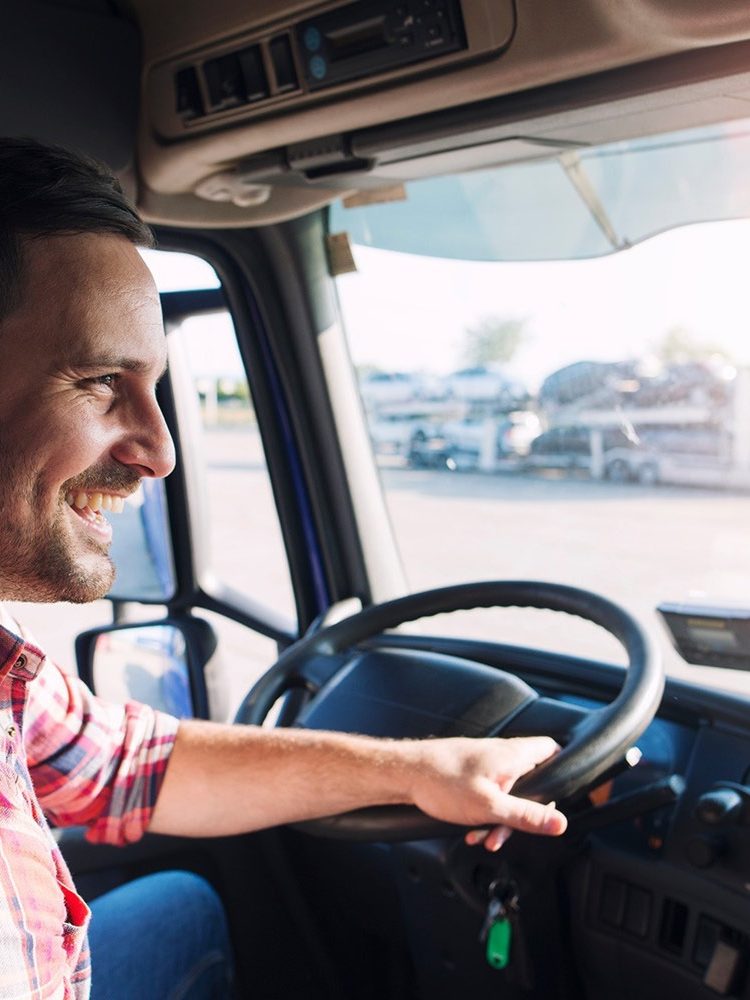 A man sitting in the driver's seat of an Intellic truck.