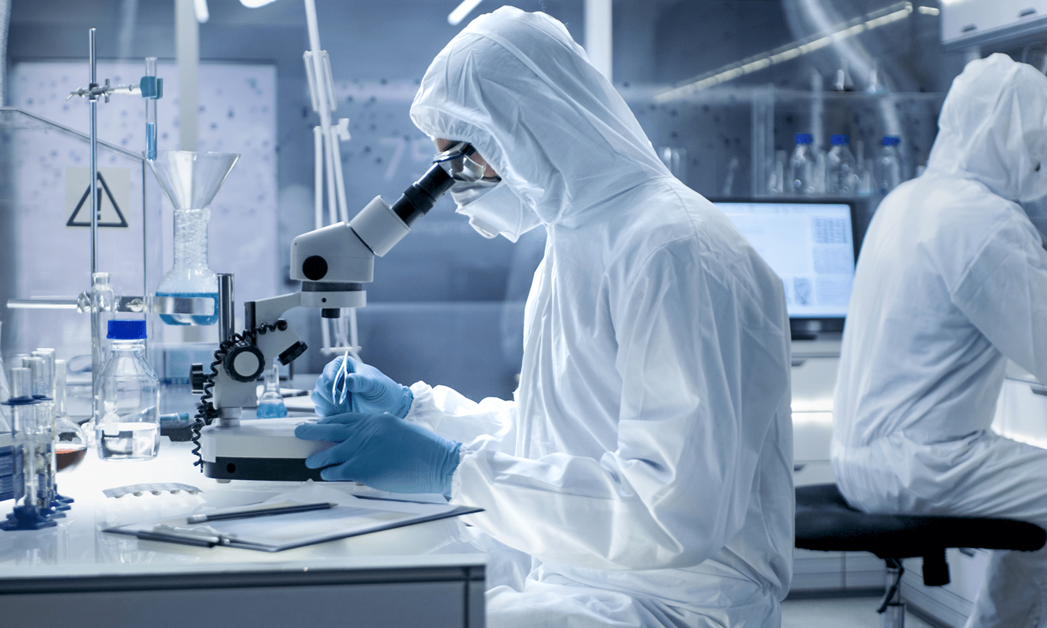 Zwei Personen in weißen Laborkitteln arbeiten in einem Labor für Curium Pharma. Zwei Personen in weißen Laborkitteln arbeiten in einem Labor für Curium Pharma.