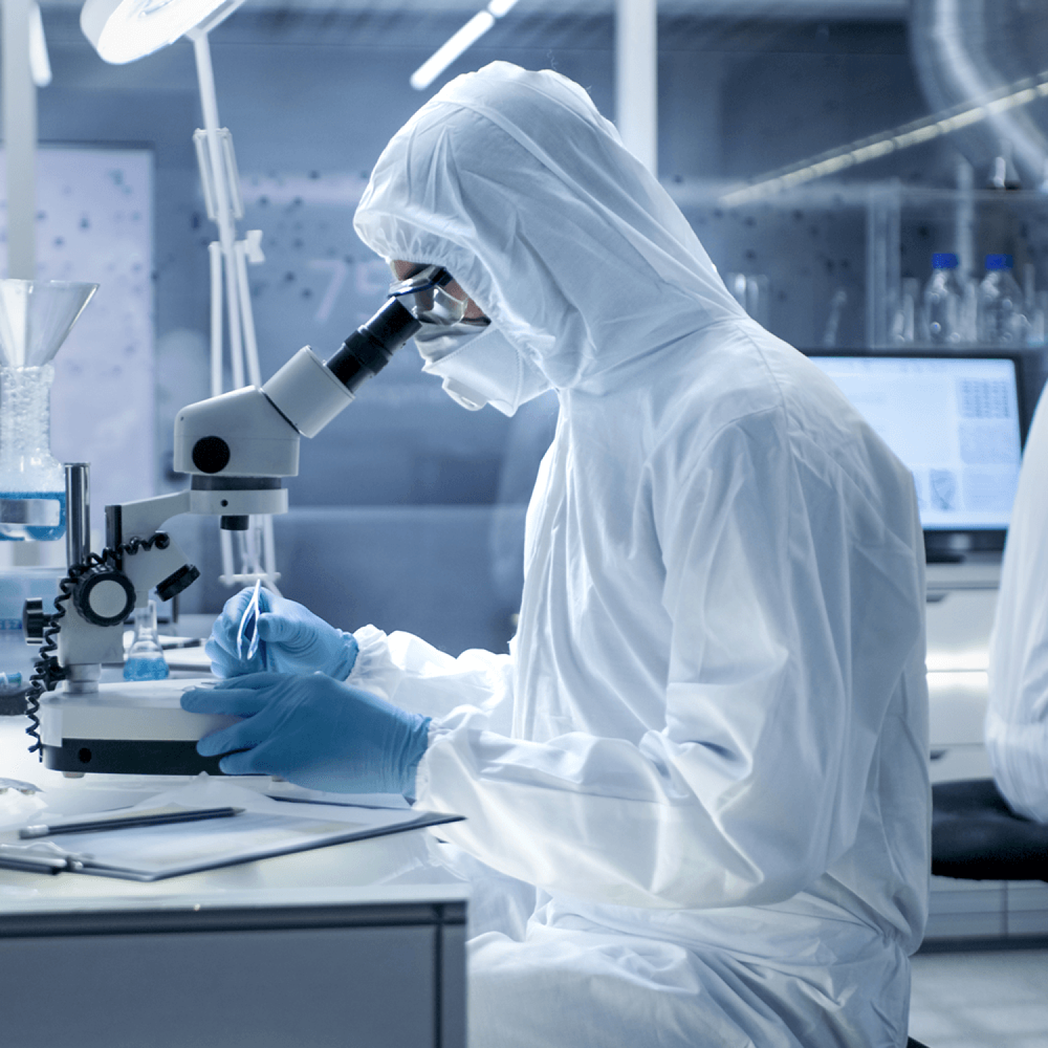 Zwei Personen in weißen Laborkitteln arbeiten in einem Labor für Curium Pharma. Zwei Personen in weißen Laborkitteln arbeiten in einem Labor für Curium Pharma.